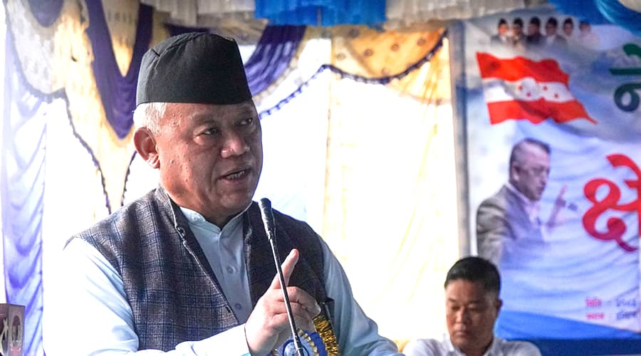 Nepali Congress leader Bhishma Raj Angdembe speaks into a microphone at a party programme.