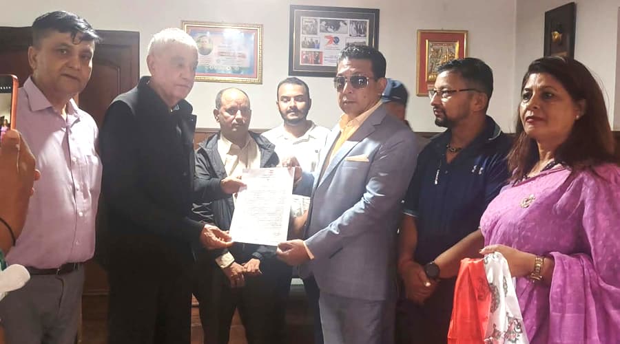 Dr. Shashank Koirala hands an official document to Rajiv Gurung, known as Deepak Manange, upon his induction into the Nepali Congress.