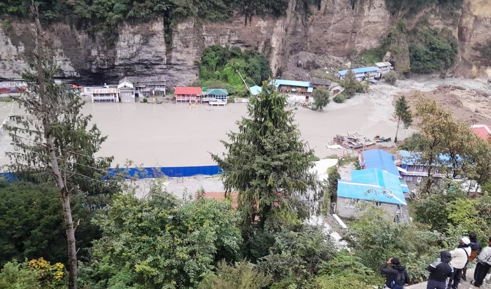 High-angle view of an artificial lake formed by the blocked Marsyangdi River submerging parts of a settlement in Manang.
