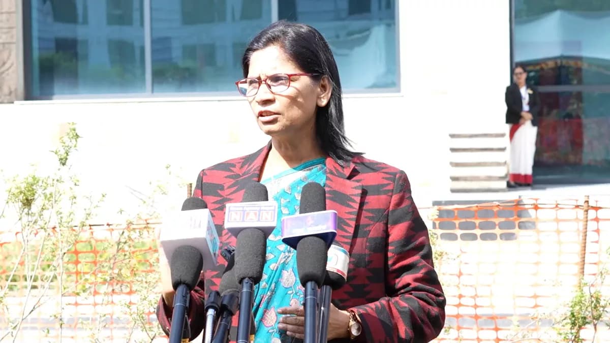 CPN-UML Secretary Padma Aryal speaks into media microphones outside the parliament building.