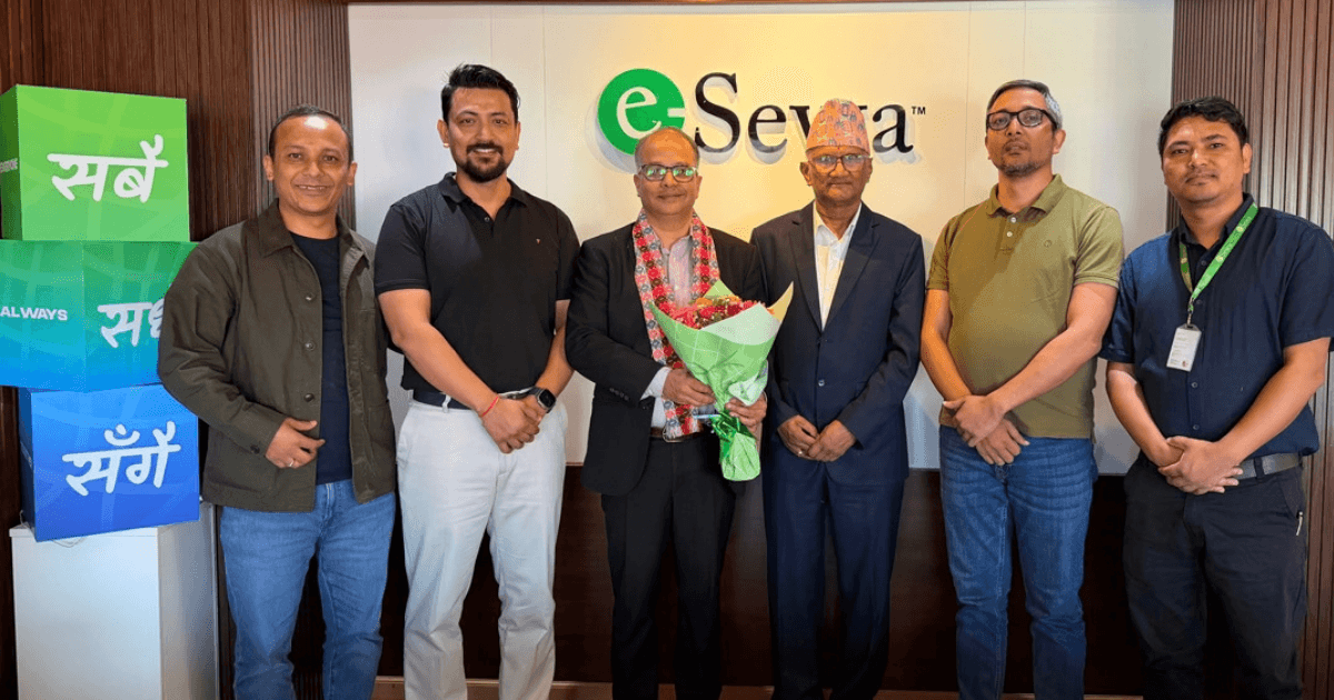 Niraj Sharma stands holding a flower bouquet alongside eSewa executives in front of the company logo.