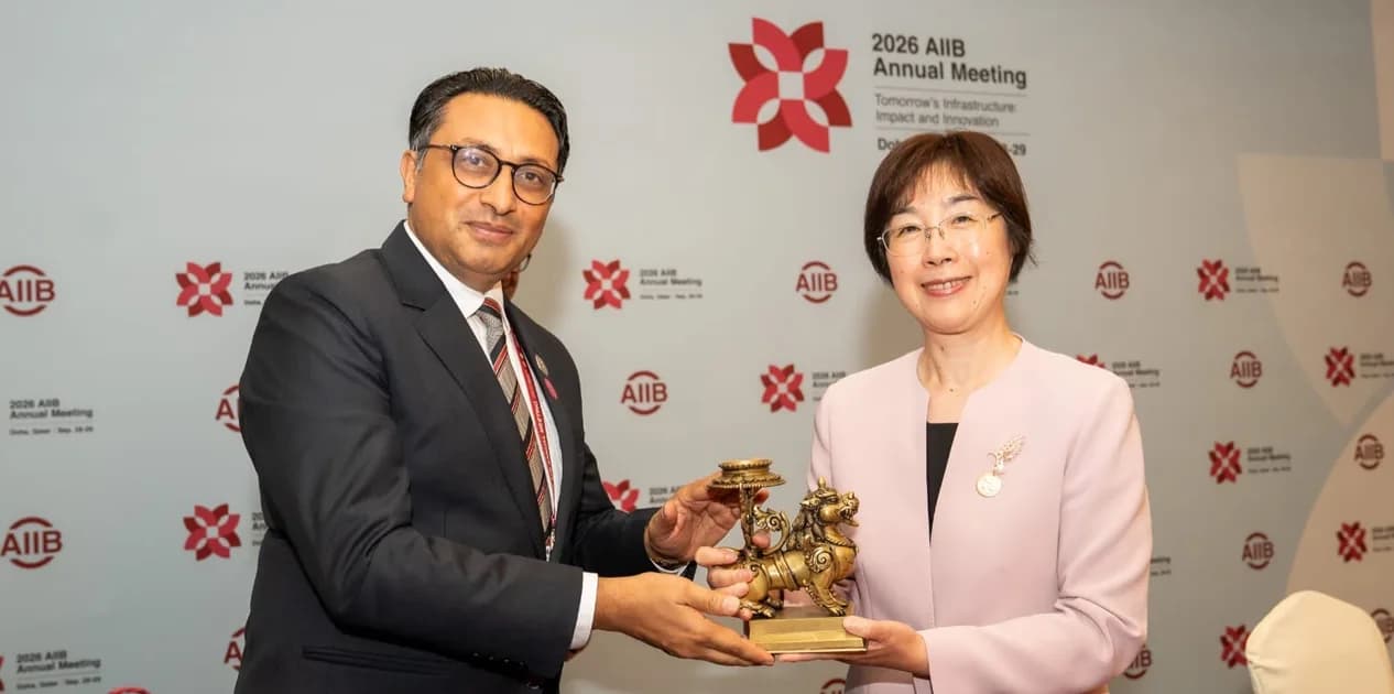 Nepal's Finance Minister Swarnim Wagle hands a traditional metal statue to an AIIB official during the bank's annual meeting.