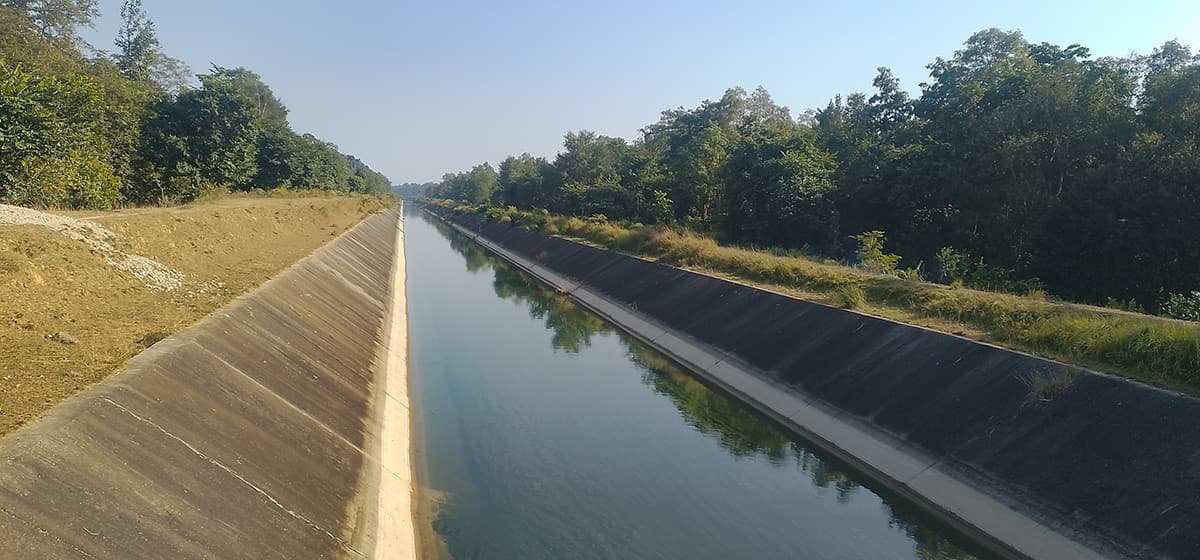 Concrete-lined canal of the Sikta Irrigation Project flowing through a rural landscape.