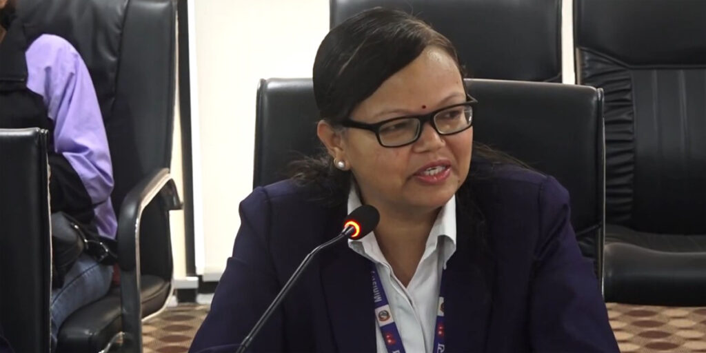 NDRRMA spokesperson Shanti Mahat speaking into a microphone during a meeting.